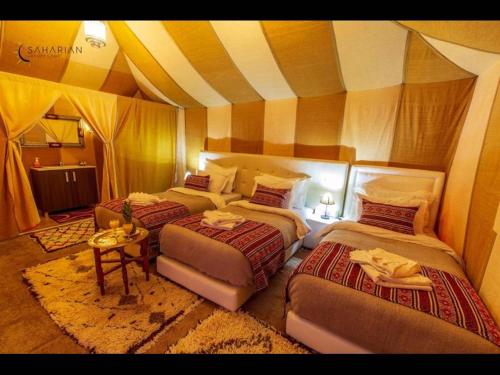 a bedroom with three beds in a room at Deluxe triple room for three at Saharian Luxury Camp in Tisserdmine