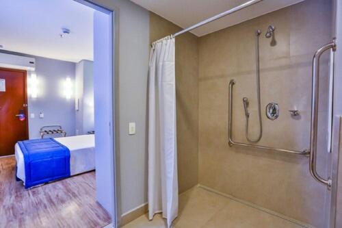 uma casa de banho com chuveiro e uma cama num quarto em Go Inn Santo André em Santo André