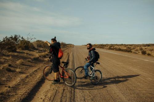 馬德琳港的住宿－Chepatagonia Hostel & Experiences，两个人骑着自行车在土路上