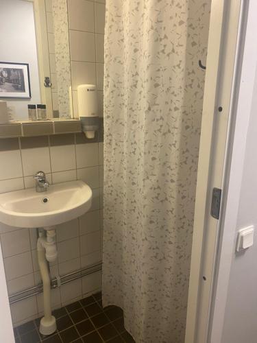 a bathroom with a sink and a shower curtain at Metro Apart Hotel in Stockholm