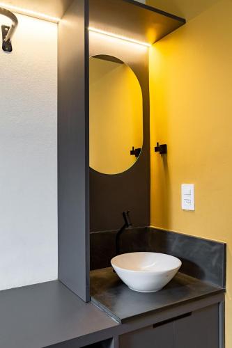 a bathroom with a sink and a mirror on a counter at ZEST Teodoro in Sao Paulo