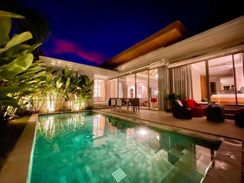 a house with a swimming pool at night at Superbe villa tropicale avec piscine privée Phuket in Phuket