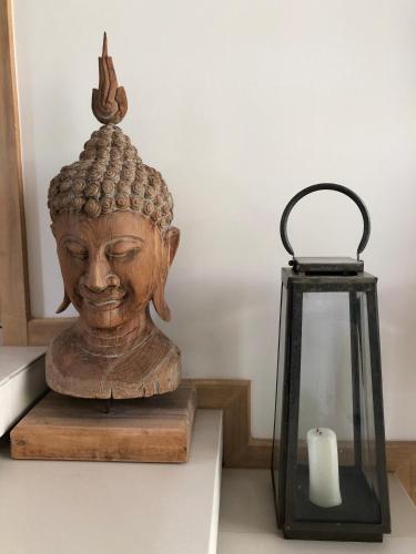 a statue of a head next to a candle at Superbe villa tropicale avec piscine privée Phuket in Phuket