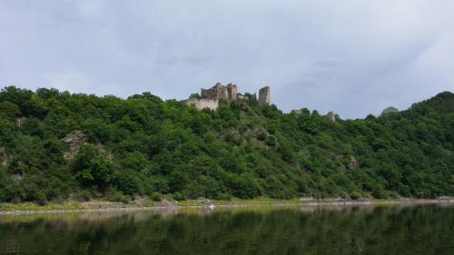 a castle on top of a hill next to a body of water at Chata Vranov in Vranov nad Dyjí