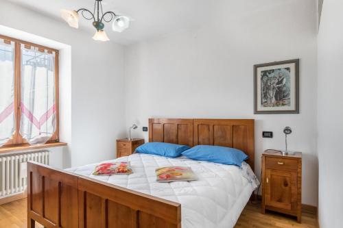 Un dormitorio con una gran cama de madera con almohadas azules en Appartamento Tra i Due Laghi, en Baselga di Pinè