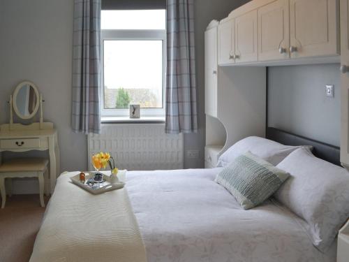 a bedroom with a bed with a tray of flowers on it at Fairground Cottage in Rothbury