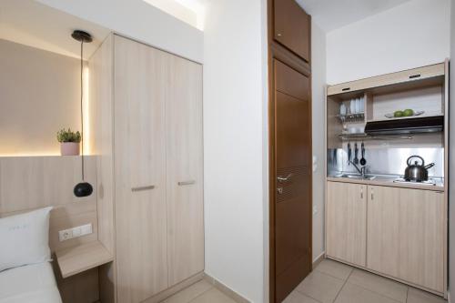 Una pequeña cocina con gabinetes blancos y un refrigerador. en Polis Apartments, en Tesalónica