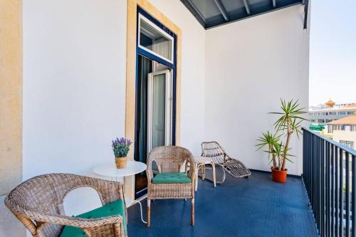 a patio with chairs and a table on a balcony at Conde 3BDR Luxury in Lisbon