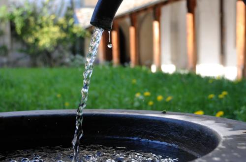 a stream of water pouring into a black bucket at Kloster Kappel in Kappel am Albis