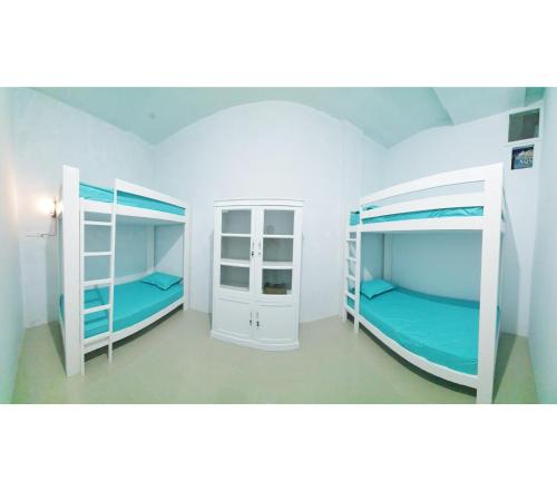 two bunk beds in a room with blue walls at Depik Inn in Takengon