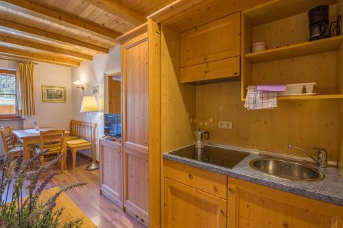 a kitchen with a sink and a dining room at Appartamenti Sonnenuhr in Sesto
