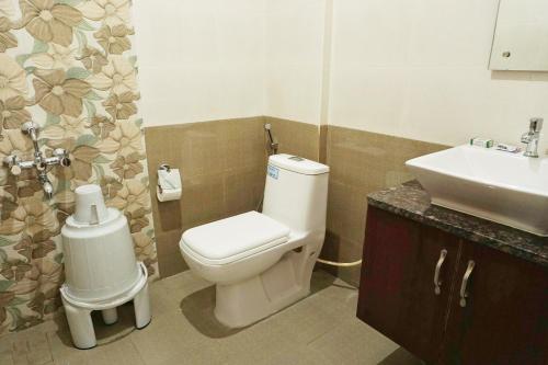 a bathroom with a toilet and a sink at Gateway Inn in Bangalore