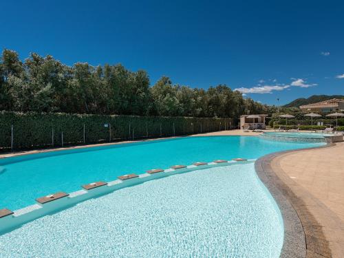 a large swimming pool with chairs in a resort at Ville D'Ogliastra in Cardedu