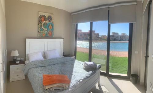 sypialnia z łóżkiem i dużym oknem w obiekcie Tawila, 4 Bedroom Villa, Brand new, directly on a lagoon w mieście Hurghada