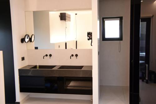 a bathroom with a sink and a mirror at White and Black Aegina in Áyioi Asómatoi