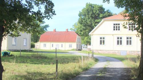 a house with a red roof next to a road at Yxkullsund Säteri B&B - Manor & Estate since 1662 in Lagan
