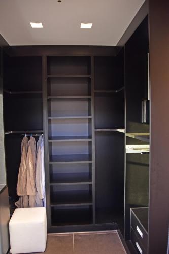 a closet with black shelves and a white stool at White and Black Aegina in Áyioi Asómatoi