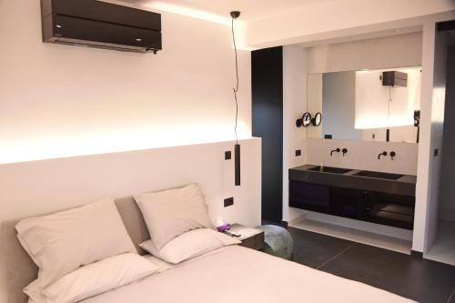 a bedroom with a bed and a sink in it at White and Black Aegina in Áyioi Asómatoi