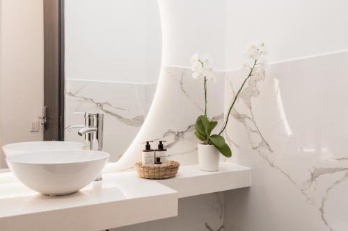 La salle de bains blanche est pourvue d'un lavabo et d'un miroir. dans l'établissement Bo Living 81, à Bogotá