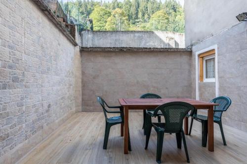 a table and chairs in a room with a brick wall at Appartamento Edik in Folgaria