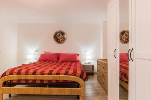 a bedroom with a bed with a red blanket at Appartamento Edik in Folgaria