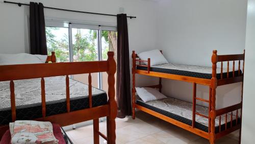 two bunk beds in a room with a window at CONFORTO e SEGURANÇA SDU AP02 in Guaratuba