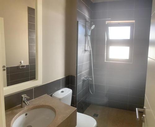 ein Bad mit einem Waschbecken, einem WC und einem Fenster in der Unterkunft Tawila, 4 Bedroom Villa, Brand new, directly on a lagoon in Hurghada