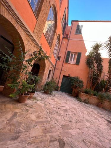 un edificio in mattoni con piante in vaso di fronte ad esso di B&B letterario Palazzo Pistocchi a Teramo