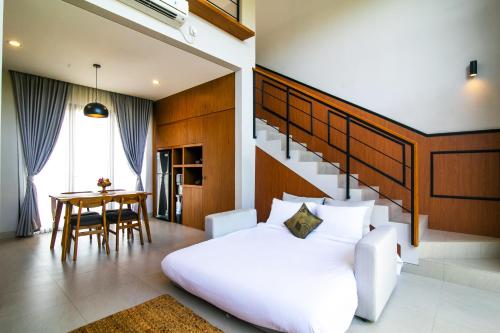 een slaapkamer met een wit bed en een tafel bij De Hsahe Villas in Tanah Lot