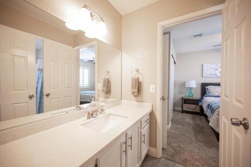 a bathroom with a sink and a mirror and a bed at Brilliant 4 Bedroom House With Pool! in Las Vegas