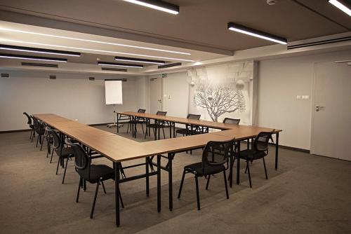 ein großer Konferenzraum mit einem langen Tisch und Stühlen in der Unterkunft Abton Hotel in Łódź