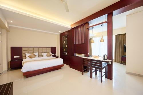 a bedroom with a bed and a desk and a deskablish at Thekkady Gavi Suites in Vandiperiyār