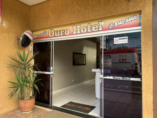 a hotel entrance with a potted plant in front of it at Ouro Hotel in Ourinhos