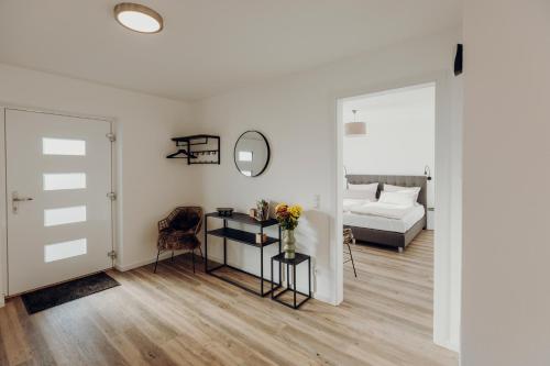 a white room with a bed and a table with flowers at Allgäu-FeWo-Niso in Waltenhofen