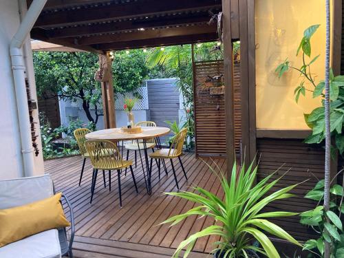 a wooden deck with a table and chairs on it at Bungalow Tec-Tec St Leu in Saint-Leu