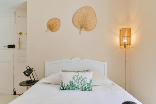 une chambre avec un lit blanc avec un oreiller dessus dans l'établissement Studio rénové Hyper Centre- Ajaccio, à Ajaccio