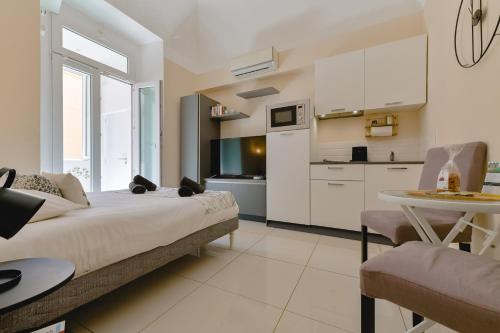 une chambre avec un lit et une table et une cuisine dans l'établissement Studio rénové Hyper Centre- Ajaccio, à Ajaccio
