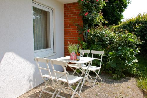 einen weißen Tisch und Stühle auf einer Terrasse in der Unterkunft Unter den Linden - 3 in Dahme