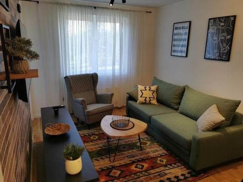 a living room with a green couch and a table at Apartman Dream Jahorina Snjezna Dolina in Jahorina