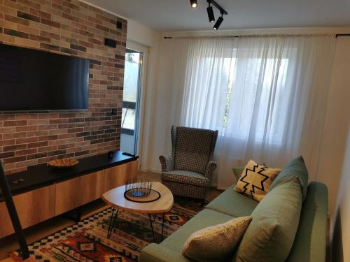 a living room with a couch and a flat screen tv at Apartman Dream Jahorina Snjezna Dolina in Jahorina