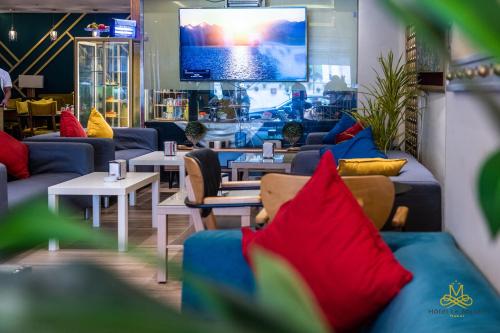 a living room with couches and tables and a tv at Hotel Le Mus&eacute;e in Rabat