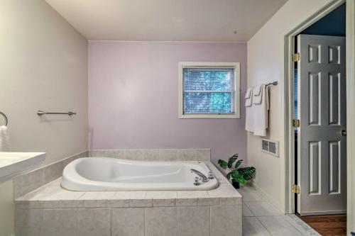 baño con bañera blanca y ventana en Stroudsburg Hideout in Poconos with Private Hot Tub!, en Stroudsburg