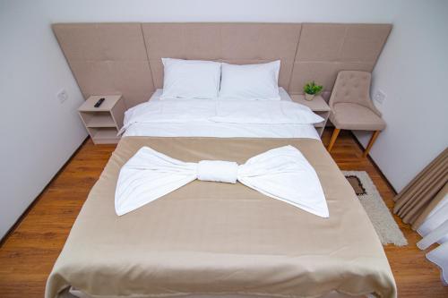 a bedroom with a bed with a bow tie on it at Hotel Konačište Akustik in Zlatibor