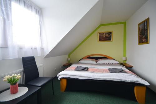 - une chambre dotée d'un lit avec un mur vert dans l'établissement Penzion Jany, à Luhačovice