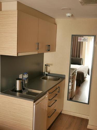 - une cuisine avec un lavabo et un miroir dans la chambre dans l'établissement Endless Comfort Hotel Taksim, à Istanbul