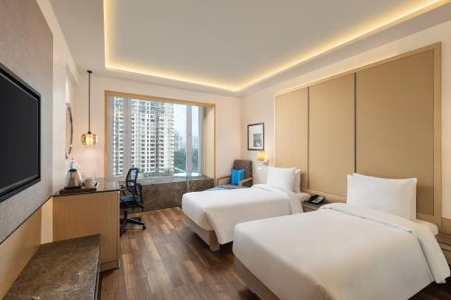 Postel nebo postele na pokoji v ubytování Radisson Mumbai Goregaon