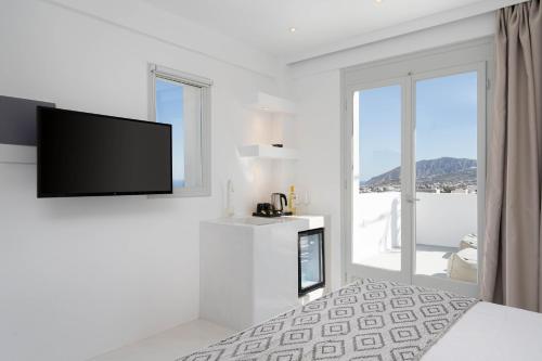 a white room with a flat screen tv on a wall at Cycladic Suites & Spa in Fira