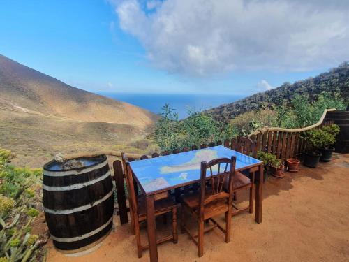 einen Tisch und Stühle mit Meerblick in der Unterkunft La Chusmita in Valverde