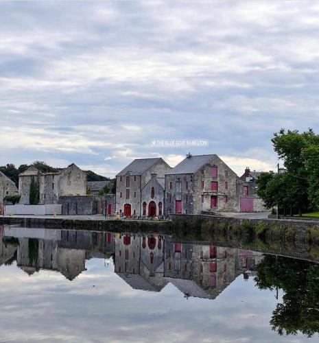 an old building sitting next to a body of water at Riverfront Apartments at The Blue Goat Ramelton in Ramelton