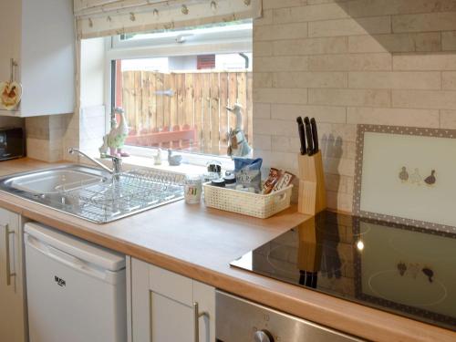 a kitchen counter with a sink and a window at Drake Lodge in Staithes